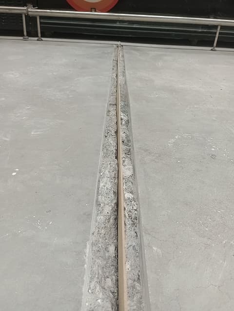 Junta de piso aberta e limpa até o concreto sadio, com sarrafo no centro, no corredor dos expositores refrigerados