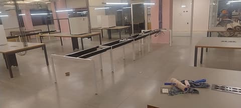Salão de escritório com bancadas instaladas e piso de granilite fosco antes da revitalização
