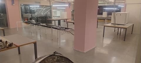 Outra vista do salão de escritório com granilite opaco, mesas e pilar ao centro