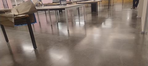 Granilite revitalizado visto de perto, com o agregado aparente e reflexo das luminárias