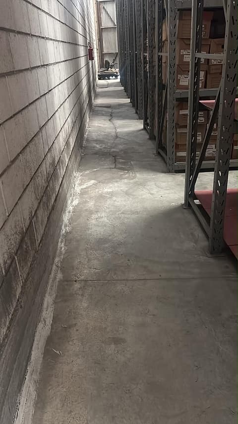 Faixa de piso reconstruída com acabamento liso entre a parede e as estruturas de armazenagem