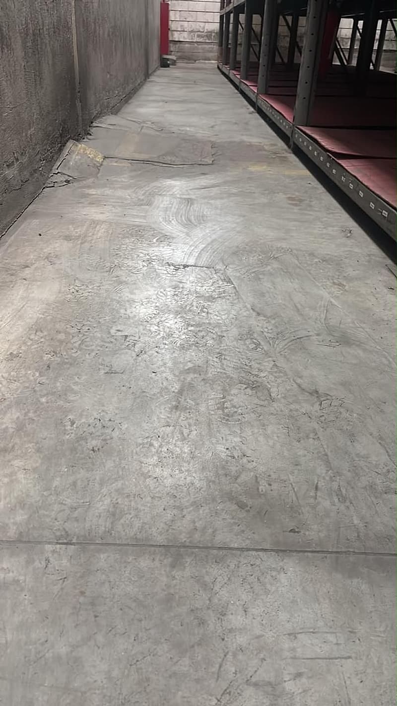 Faixa de piso nova vista ao longo do corredor junto à parede, com as estruturas de armazenagem à direita