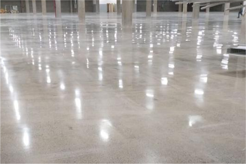 Galpão logístico vazio com piso de concreto lapidado espelhado refletindo as luminárias