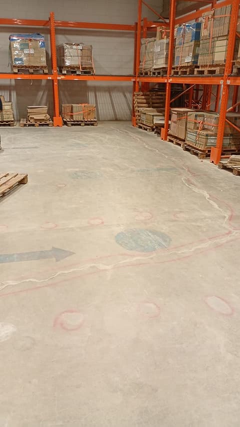 Rua de circulação do depósito com o piso recuperado e estruturas de armazenagem dos dois lados