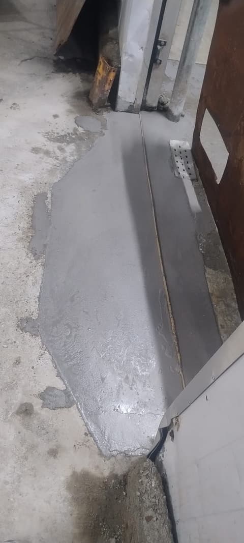 Soleira da câmara fria recomposta com argamassa cinza junto à porta