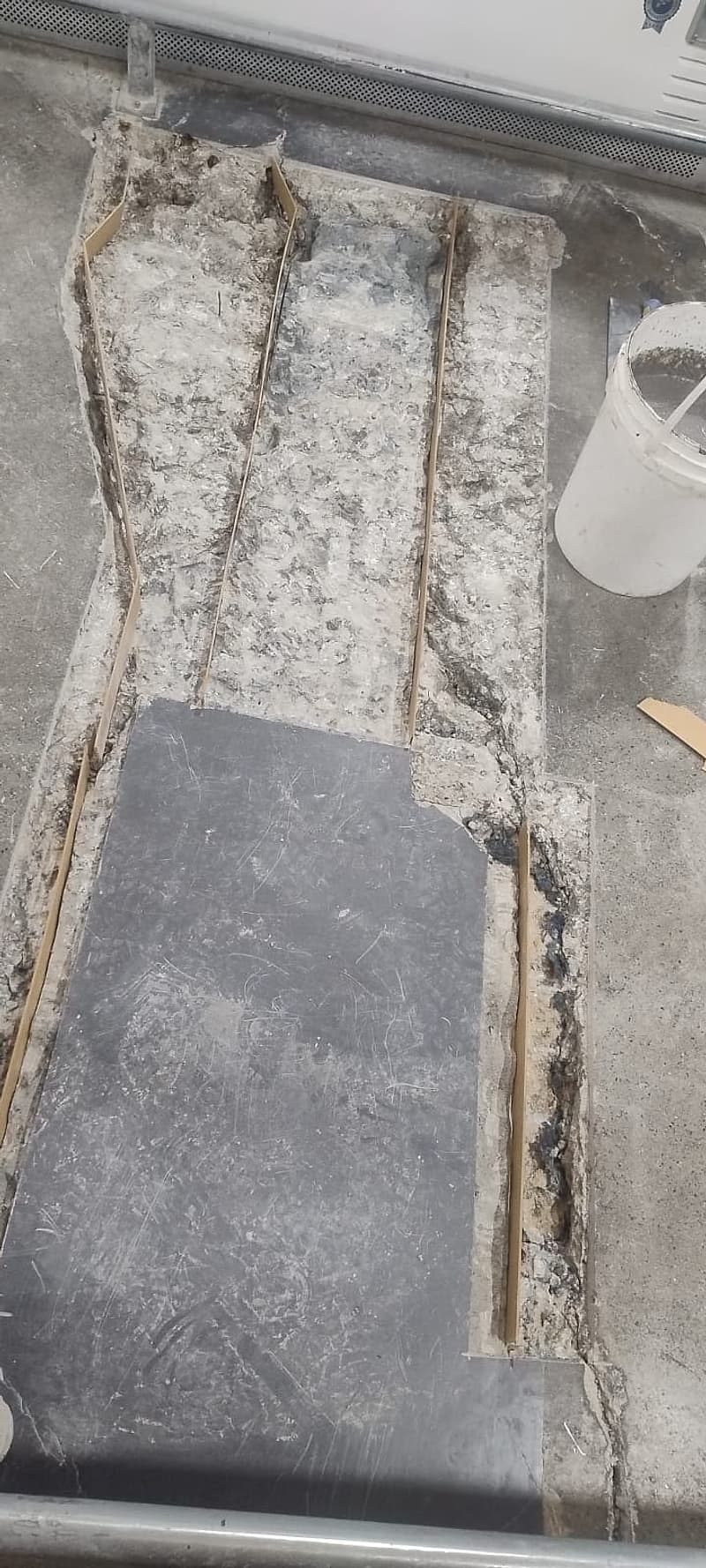 Remendo antigo aberto e solto no piso interno da loja, com bordas deterioradas