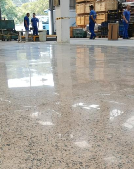 Piso de concreto lapidado em oficina industrial com operadores ao fundo