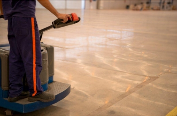 Operador de paleteira elétrica circulando sobre piso de concreto industrial restaurado